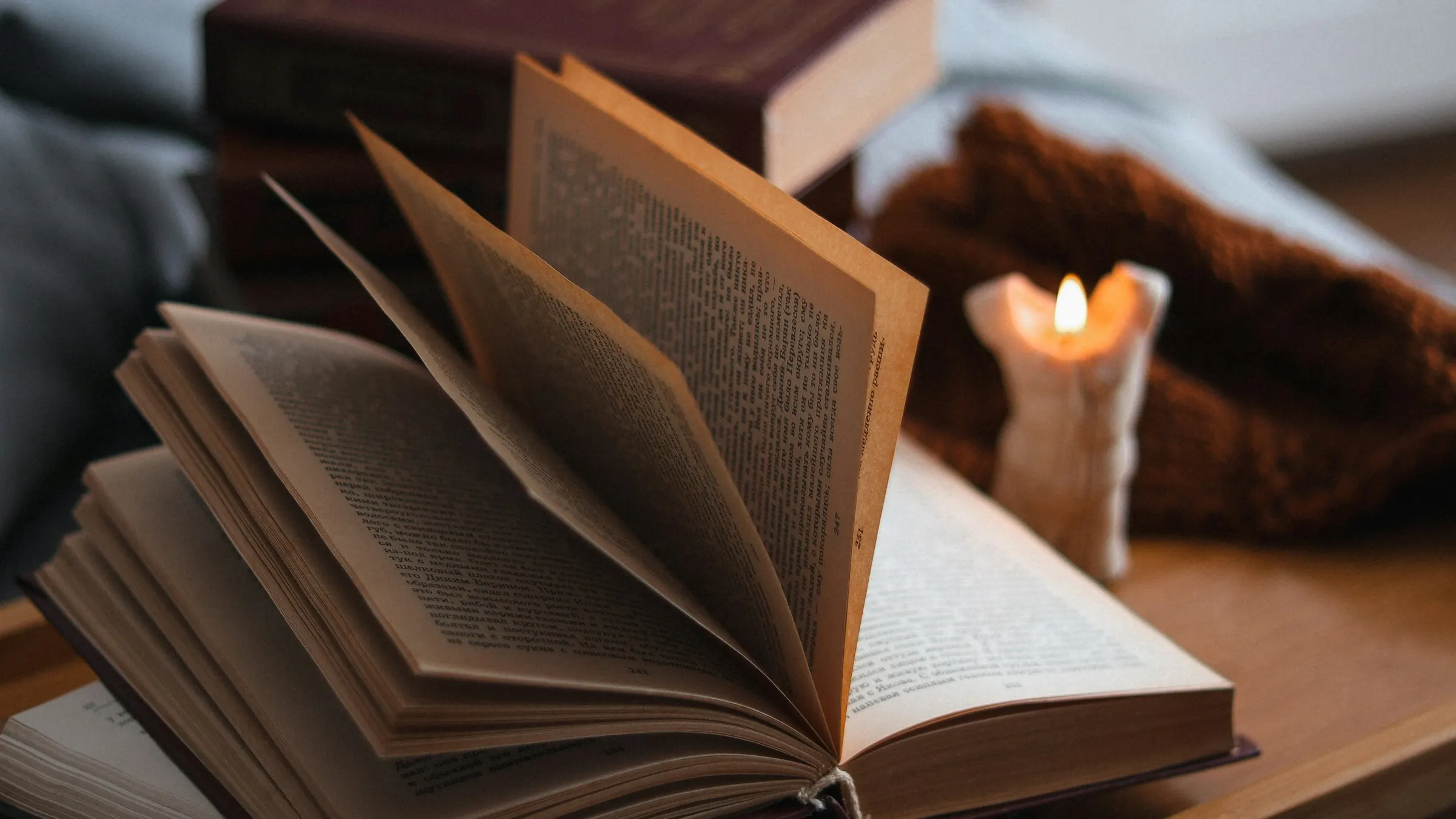 Ein aufgeschlagenes Buch bei Kerzenlicht